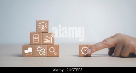 Businessman hand holding wood cubes with light bulb icon, HR Human and people icon,Technology Process System Business with Recruitment, Hiring, Team B Stock Photo