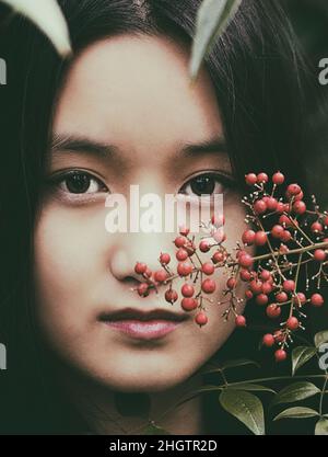 Chinese girl among red berries III Stock Photo