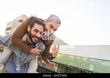 Happy gay couple man embrace in love outdoors. Cheerful LGTB people having fun together Stock Photo