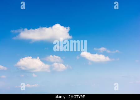 sky with fluffy clouds. white cumulus sparse cloudscape on a deep blue gradient of atmosphere. sunny summer weather. beautiful nature background. mete Stock Photo