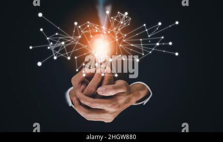 The Man hand holding light bulb with line connect and working on the desk, Creativity and innovation are keys to success.Concept of new idea and innov Stock Photo