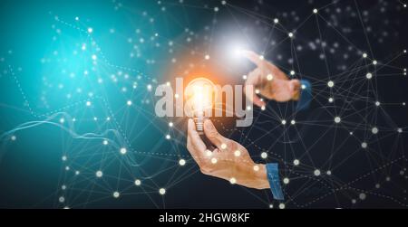 The Man hand holding light bulb with line connect and working on the desk, Creativity and innovation are keys to success.Concept of new idea and innov Stock Photo