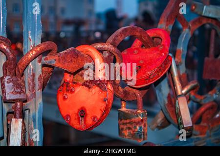Rusty love red romantic lock on a bridge. Russia, Kaliningrad - January 16, 2022. Stock Photo
