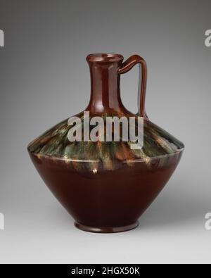 Jug ca. 1880 Christopher Dresser The bold form and rich glaze of this jug are characteristic of Christopher Dresser's designs at Linthorpe Pottery Works, where he served as director from 1879 to 1882. The form is probably based on Minoan or Cycladic pottery, as were many of Dresser's designs for Linthorpe. However, Asian, Mexican, Peruvian, and Fijian pottery, as well as prehistoric artifacts found in Yorkshire were also sources of inspiration, indicating Dresser's penchant for adapting motifs from diverse cultures. At Linthrope, vessels were potted by hand and then finished in a wood mold. Th Stock Photo