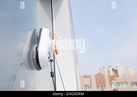 Robot cleaner work outside the dirty window. Cleaning the house with smart devices. Automatic vacuum robots for cleaning windows, an assistant for the Stock Photo