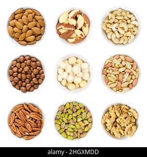 Nine different kinds of nuts in white bowls. Almond kernels, brazil nuts, cashews, hazelnuts, macadamia nuts, peanuts, pecans, pistachios, and walnuts Stock Photo