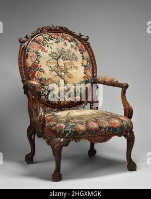 Armchair (one of four) 1755–65 Tapestry probably woven at Royal Manufactory Beauvais 1664-1789 This rococo chair is part of a larger set of seat furniture supplied to the third Duke of Ancaster (1714–1778) for Grimsthorpe Castle, Lincolnshire. Executed in the French taste, fashionable in mid-eighteenth century England, the set was originally partly gilt and upholstered with Gobelins tapestry (now in the Rijksmuseum, Amsterdam) after designs by the painter François Boucher. The present covers were applied between 1934 and 1958.. Armchair (one of four). British and French, probably Beauvais. 175 Stock Photo
