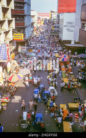 A busy streetscene of retail shopping outlets and market stalls on crowded Carriedo Street in the Quiapo district of Metropolitan Manila, Luzon Island, the Philippines. Stock Photo