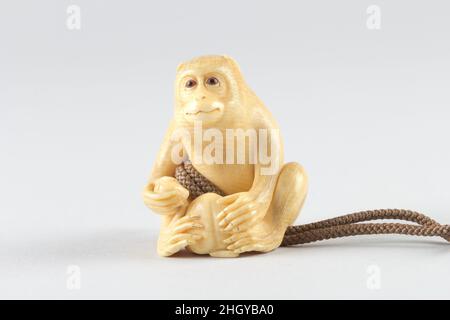 Netsuke of Seated Monkey with Persimmon 19th century Japan. Netsuke of Seated Monkey with Persimmon. Japan. 19th century. Ivory. Netsuke Stock Photo