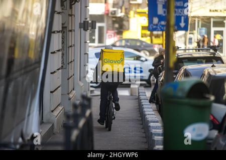 Bucharest, Romania - January 04, 2022: A Glovo food delivery courier delivers food in Bucharest, Romania. Stock Photo