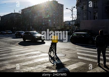 Bucharest, Romania - January 04, 2022: A Glovo food delivery courier delivers food in Bucharest, Romania. Stock Photo