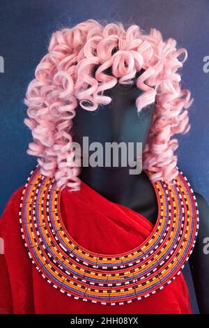 Mannequin with pink hair, deep read clothes, and a Maasai beaded necklace. Stock Photo