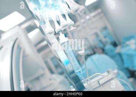 Intravenous drip on the background of working medical doctors team in the catheterization laboratory. Stock Photo