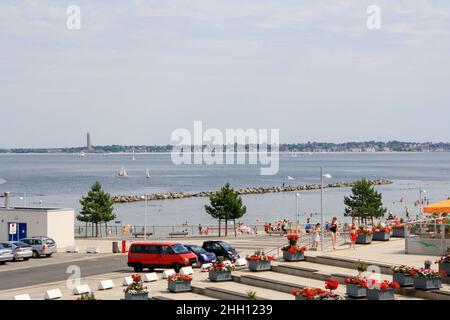 View of beach at University of Kiel sailing center in summer with Laboe naval memorial tower and clouds in blue sky background. Stock Photo