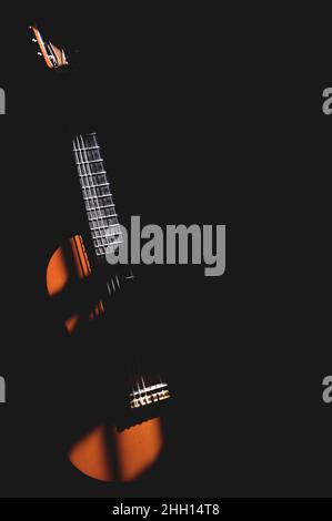 A guitar in the shadows Stock Photo