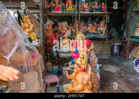 A statue of Lord Ganesha being painted by an artist at a workshop in Mumbai before the auspicious Indian festival of Ganesh Chaturthi Stock Photo