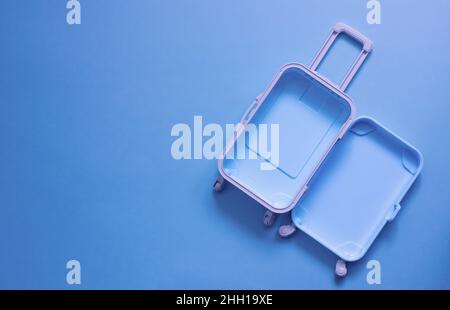 Fully opened blue suitcase, on a blue background, top view. Vacation, travel concept. copy space Stock Photo