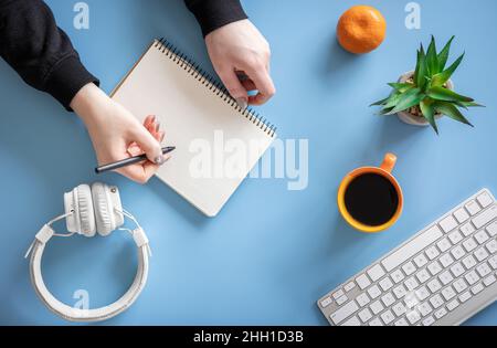 Female hands are writing in a notebook, flat lay, conceptual minimalism. Stock Photo