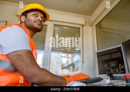 Young multiethnic operator working at construction plant Stock Photo