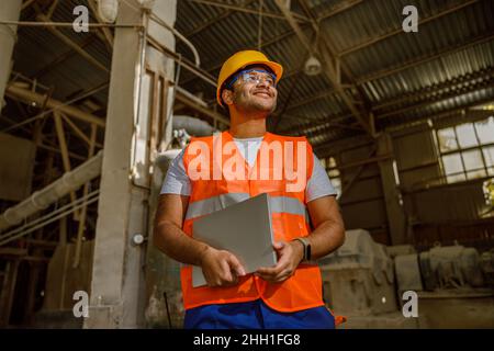 Multiethnic engineer working with laptop at plant Stock Photo