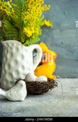 Festive table setting for Easter holiday with mimosa flowers and nest Stock Photo
