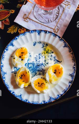 plate of soft boiled eggs with cocktail on napkin Stock Photo