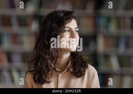 Happy dreamy beautiful student looking away, smiling at good thoughts Stock Photo