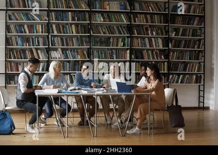 Diverse multiethnic group of students cooperating on graduation project Stock Photo