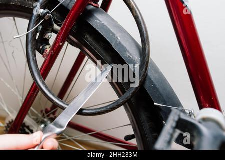 Serviceman repairing bicycle tire with tools, close up photo Stock Photo