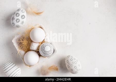 Easter eggs with geometric pattern in paper box and feathers Stock Photo