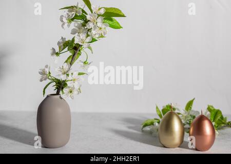 Easter composition with blooming branches and eggs shaped candles Stock Photo