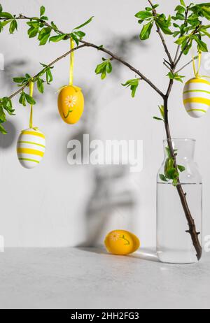 tree branches with easter painted eggs on gray background Stock Photo