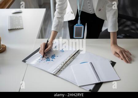 Cropped shot businesswoman putting signature on business document. Stock Photo