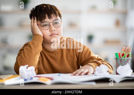 Overweight japanese boy doing school project, got tired Stock Photo