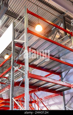 Huge distribution warehouse with high shelves and loaders. Bottom view. Stock Photo