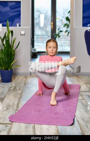 Little Girl Lying On The Floor And Doing Stretching Exercises With