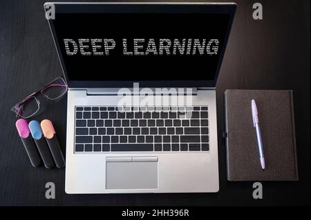 Top view of laptop with text Deep learning. Deep learning inscription on laptop screen. Stock Photo