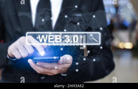 Businessman is using mobile phone pressing on virtual screen and select "Web 3.0". Concept of modern technology Stock Photo