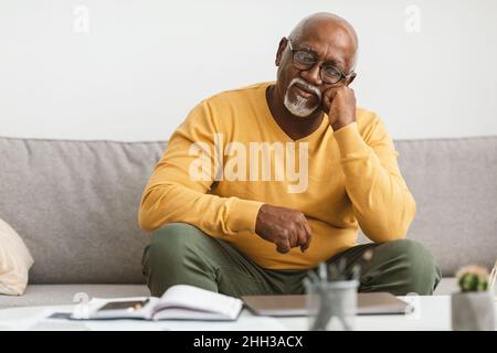Mature African American Man Sitting On Couch At Home Stock Photo