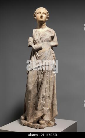 Marble and limestone statue of an attendant late 4th or 3rd century B.C. Greek, South Italian, Tarentine This young woman held an object in her right hand, perhaps a fan. The statue was originally likely part of a funerary group of an aristocratic woman with her attendant that would have served as a tomb marker. It was not uncommon during the Hellenistic period in Southern Italy to carve the heads of significant commissions in imported marble and use local limestone for the bodies. The Greek city of Tarentum had a particularly distinctive sculptural tradition of limestone funerary monuments, o Stock Photo