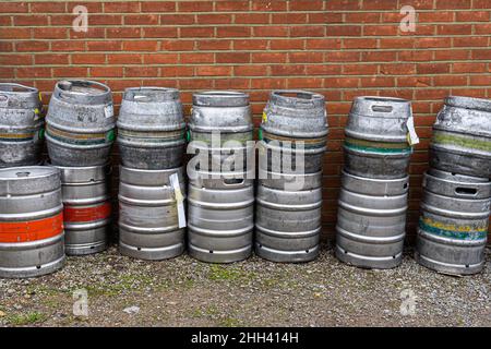 Metal beer barrels stacked outside an English pub reading for collection Stock Photo