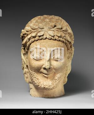 Limestone male head late 6th century B.C. Cypriot While the foliate wreath identifies the figure as a Cypriot votary, the features of the face—the mustache, the bead, the crisp lines of the eyebrows and eyelids—are clearly dependent on Archaic Greek marble models.. Limestone male head  242387 Stock Photo