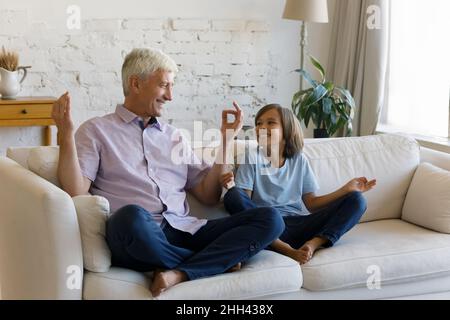 Happy healthy active grandpa teaching positive smiling teen grandson Stock Photo