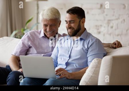 Happy mature dad and adult son spending time at home Stock Photo
