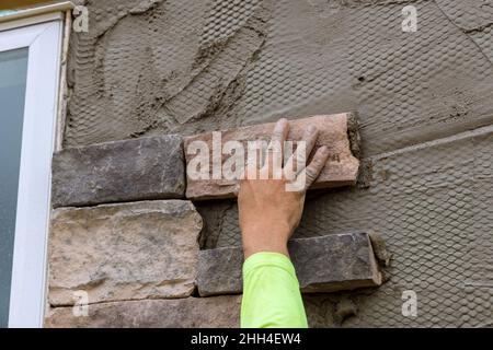 Worker gluing for decorative stone brick with cement grout. Stock Photo