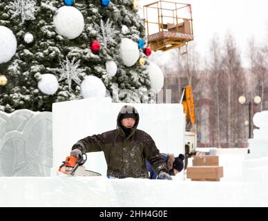 Worker with a chainsaw in hand at the assembly site Stock Photo