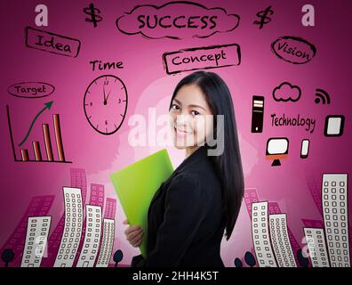 Asian attractive professional female smiling and holding green document file on pink background. Decision making process concept. Young female has man Stock Photo