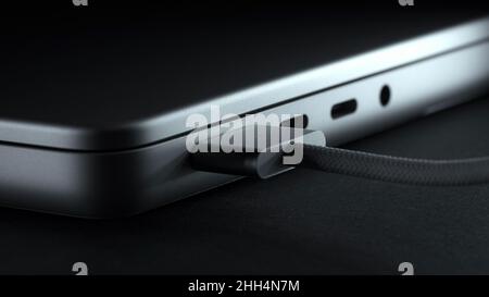 MagSafe 3 power adapter connecting to new laptop. Charger for laptop close-up. Metal silver version Stock Photo