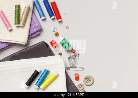 Flat lay of sewing equipment with cotton reels, buttons and measuring tape  on a white background with space for text or design Christmas colours Stock  Photo