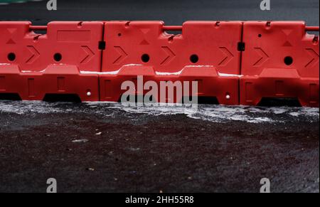 Red heavy duty plastic barrier, equipment barricading on roadside, preventing cars or another vehicles Stock Photo